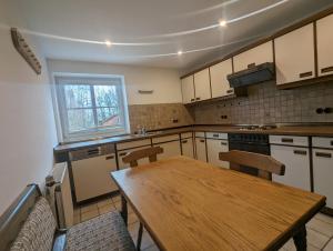 a kitchen with a wooden table and chairs in it at Ferienwohnung am Teich in Dannenberg