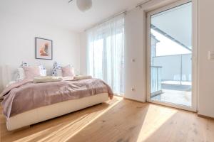 um quarto com uma cama e uma grande janela em Krems Deluxe Apartments - Newly built em Krems an der Donau
