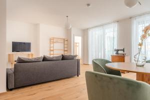 uma sala de estar com um sofá e uma mesa em Krems Deluxe Apartments - Newly built em Krems an der Donau