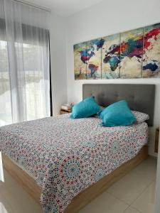 a bedroom with a bed with three paintings on the wall at Apartamento Postman in Arenales del Sol