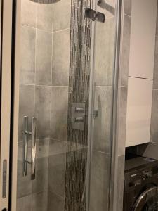 a shower with a glass door in a bathroom at Chambre Quartier Auteuil in Paris