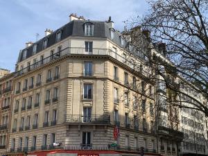 a large white building with a balcony on top of it at Chambre Quartier Auteuil in Paris