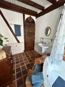 uma casa de banho com uma banheira, um lavatório e um WC. em Gemütliches Scheunenfachwerkhaus em Bad Soden am Taunus