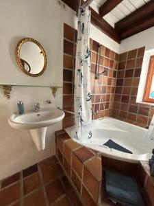 ein Badezimmer mit einem Waschbecken, einer Badewanne und einem Waschbecken in der Unterkunft Gemütliches Scheunenfachwerkhaus in Bad Soden am Taunus