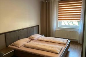 - un lit avec deux oreillers et une fenêtre dans une chambre dans l'établissement Private Apartment, à Hanovre