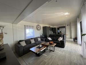 un soggiorno con divano e tavolo di Cottage haut de gamme 6 personnes avec spa & wifi a Sainte-Foy