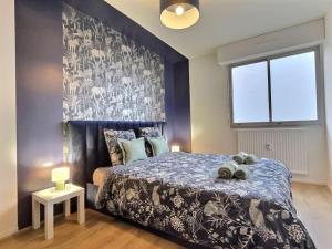 a bedroom with a bed and a large window at ''Douceur'' de Miss.K Conciergerie in Mâcon
