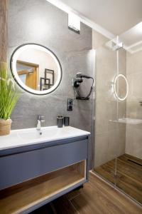 La salle de bains est pourvue d'un lavabo et d'un miroir. dans l'établissement ARAMIKA apartamenty, à Szklarska Poręba