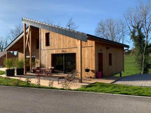 ein großes Holzhaus mit einem Tisch und Stühlen in der Unterkunft Lodges Clara Vallis in Clairvaux-les-Lacs