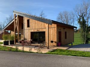 a large wooden house with a table and chairs at Lodges Clara Vallis in Clairvaux-les-Lacs