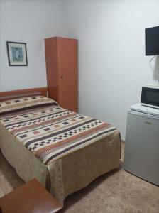 1 dormitorio con 1 cama, armario y mesa en PENSIÓN CARLOS III, en Tomelloso