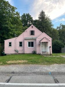une maison rose assise sur le côté d'une route dans l'établissement Cozy 4 bd house in Pitt, à Pittsburgh