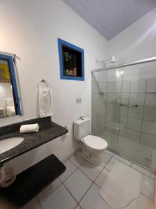 ein Bad mit einem WC und einer Glasdusche in der Unterkunft Zil Hospeda in Pipa