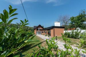 une maison sur une colline avec des plantes au premier plan dans l'établissement Villa Tina, à Velika