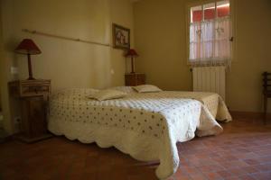 1 dormitorio con 1 cama con edredón blanco en gîte Mas Antinea, en Mazan