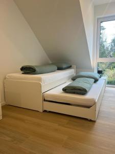 two twin beds in a room with a window at Heide-Liebe in Soltau