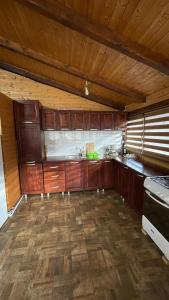 a kitchen with wooden cabinets and a wooden floor at Cabana Daianna si Jessica in Poiana Vadului
