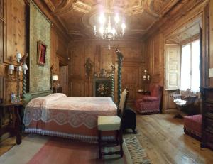 - une chambre avec un lit et un lustre dans l'établissement B&b di Charme Palazzo Lambertenghi, à Tirano