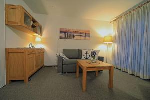un soggiorno con un divano e un tavolo di Wohnung-Hafenblick a Wittdün