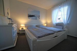 una camera da letto con un letto grande e una finestra di Wohnung-Hafenblick a Wittdün