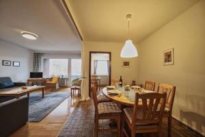 a dining room and living room with a table and chairs at Wohnung-Froemming in Wittdün