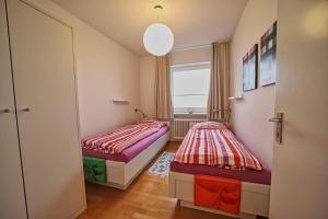 two beds in a small room with a window at Wohnung-Froemming in Wittdün
