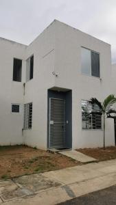 una casa blanca con una puerta azul y una palmera en Casa Paraíso tropical, en Techoh