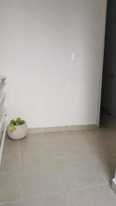a room with a white wall and a vase on the floor at Casa Paraíso tropical in Techoh
