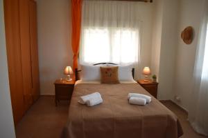 a bedroom with a large bed with two towels on it at Casa Milady in Sozopolis, Halkidiki in Sozopoli