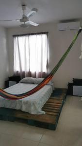 hamaca en un dormitorio con ventana en Casa Paraíso tropical, en Techoh