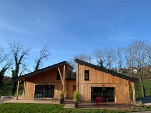 a barn style house with a black roof at Maison Cosy 10 personnes in Clairvaux-les-Lacs