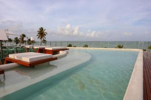 a swimming pool with a view of the ocean at Setai Yacht Premium - By Almare Flats in João Pessoa
