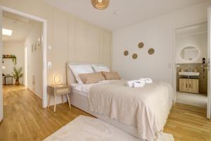 a white bedroom with a bed and a bathroom at Exklusive 3-Zimmer Luxus Maisonette Wohnung in Hochheim, Nähe FFM Flughafen in Hochheim am Main