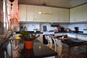 a kitchen with white cabinets and a table with chairs at Casa Milady in Sozopolis, Halkidiki in Sozopoli