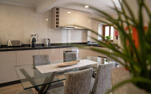 a kitchen with a glass table and chairs at Casas do relógio in Penamacor