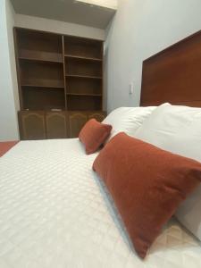 uma cama branca com duas almofadas em cima em Hotel Boutique Iyarí em Palmira