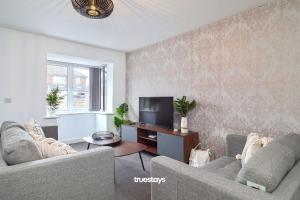 a living room with two couches and a television at Denton House by Truestays - NEW 3 Bedroom House in Manchester in Manchester