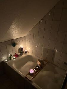 a bath tub with candles and a box in it at FroschKönig in Norden