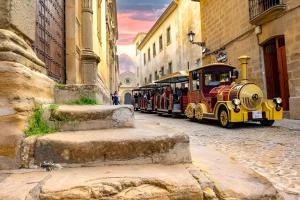 a small train on a street in a city at El ventanal del viajero in Baeza