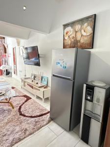 uma cozinha com um frigorífico de aço inoxidável e uma televisão em Sea la vie II em Kwale