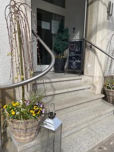 a basket of flowers on the steps of a building at Hotel Anker in Rottenburg