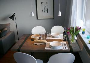 a dining room table with white chairs and a table with plates and bowls at Wohnung-Kaufhold in Wittdün