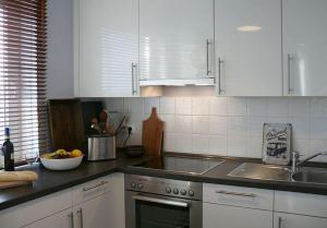 a kitchen with white cabinets and a bowl of fruit on the counter at Wohnung-Kaufhold in Wittdün +8 photos