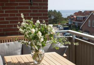 a vase of flowers sitting on a table on a balcony at Wohnung-Kaufhold in Wittdün