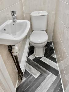 La salle de bains est pourvue de toilettes blanches et d'un lavabo. dans l'établissement Westfield London Shepherds Bush, à Londres