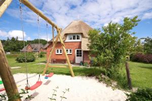 a swing in front of a house at Skuch-Looden in Süddorf +2 photos