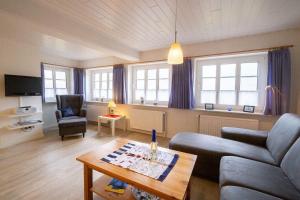 a living room with a couch and a table at Skuch-Looden in Süddorf