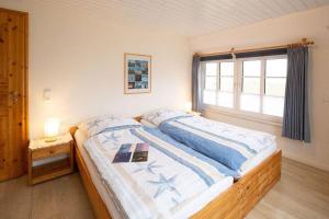 a bedroom with a large bed with a window at Skuch-Looden in Süddorf