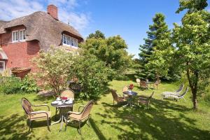 un cortile con tavoli e sedie di fronte a una casa di Auer-Werksteed a Süddorf