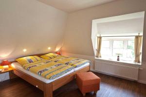 una camera da letto con un letto con cuscini gialli e una finestra di Auer-Werksteed a Süddorf